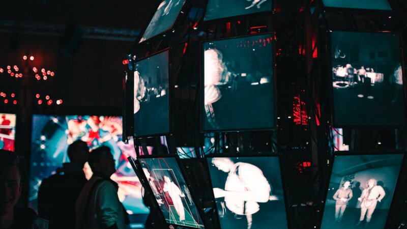 a group of people standing around a display of video screens